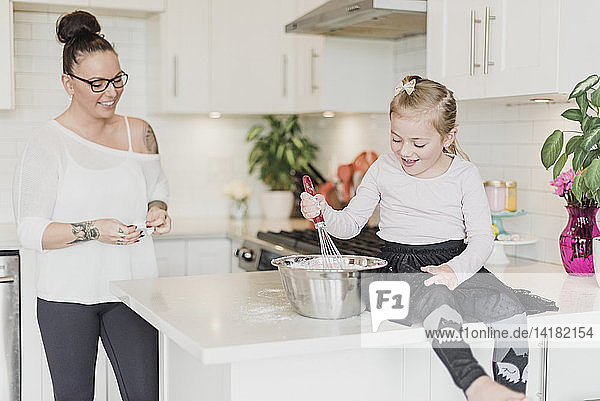 Mother and daughter baking in kitchen