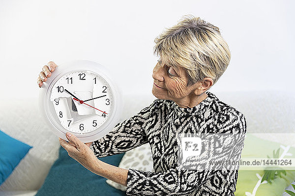 Ältere Frau mit einer von der Zeit getragenen Uhr.
