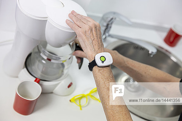 Elderly woman with a medical alert system around her wrist.
