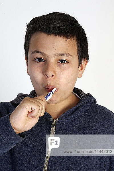 12-jähriger Junge putzt sich die Zähne.