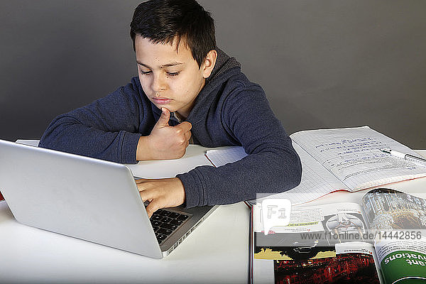 12-jähriger Schüler macht seine Hausaufgaben mit einem Laptop. Paris  Frankreich.