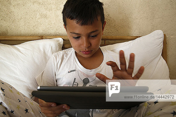 11-jähriger Junge spielt mit einem digitalen Tablet in Salento  Italien.
