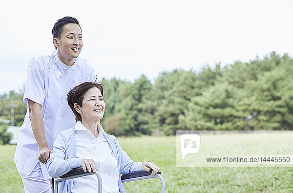 Japanese caretaker helping senior patient