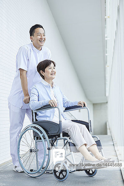 Japanische Pflegerin hilft älteren Patienten