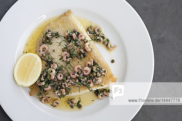 Skate wing with freshwater prawns  brownbutter  capers and a lemon wedge