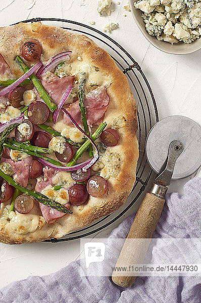 Pizza mit Schinken, Weintrauben, Spargel und Blauschimmelkäse