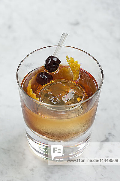 Whiskey-Cocktail mit einer Kugel aus Eis