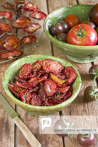Getrocknete Tomaten auf einem Drahtgitter und in einer Keramikschale