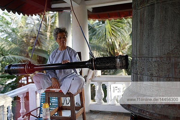 Phuoc Thanh buddhistische Pagode. Buddhistischer Verehrer läutet Glocke. Cai be. Vietnam.