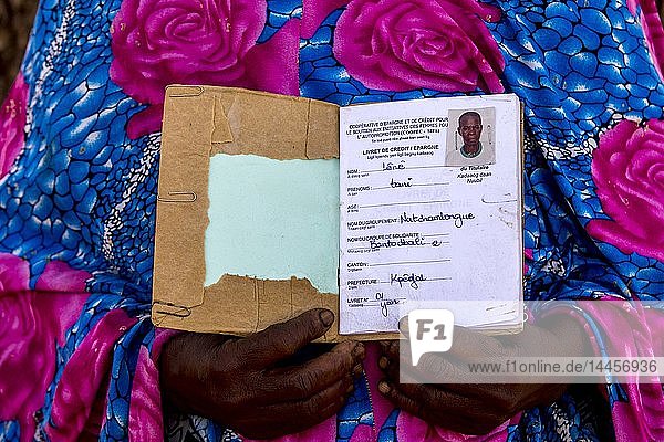 Mitglied einer Mikrofinanzgenossenschaft von Frauen zeigt ihr Sparbuch im Norden Togos.