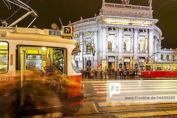 View of Burgtheater and city trams at night in Rathausplaza  Vienna  Austria