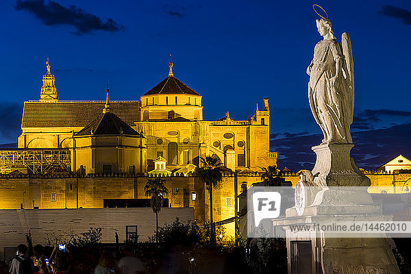 Statue auf der Römischen Brücke und die Moschee-Kathedrale (Große Moschee von Cordoba) (Mezquita)  UNESCO-Weltkulturerbe  in der Abenddämmerung  Cordoba  Andalusien  Spanien