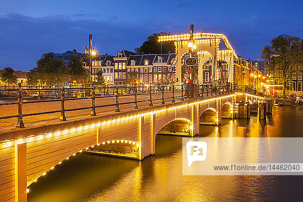 Illuminated Magere brug (Skinny Bridge) at night spanning the River Amstel  Amsterdam  North Holland  Netherlands