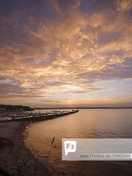Bunte Sonnenuntergangsansicht von Breakwater Beach und der Hafenmauer von Brixham  Devon  England  Vereinigtes Königreich