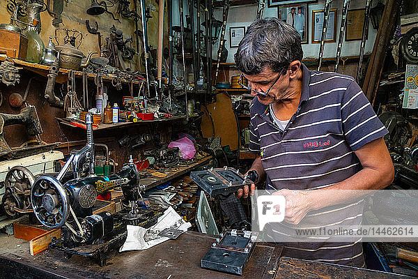 Man in his mechanical repair shop in an alleyway in the Old City (Medina) of Fez UNESCO World Heritage Site Morocco North Africa