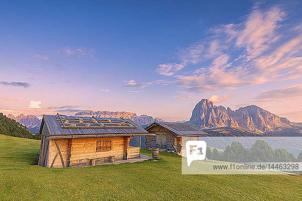 Traditional huts at sunset with Sassolungo and Sella Group in the background  Gardena Valley  South Tyrol  Dolomites  Italy