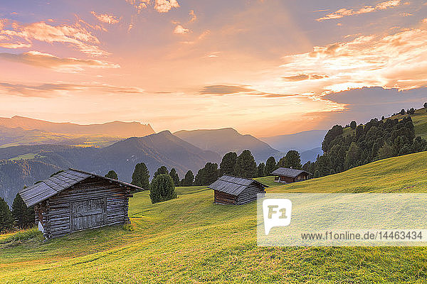 Sonnenuntergang über traditionellen Hütten auf der Alm  Grödner Tal  Südtirol  Dolomiten  Italien