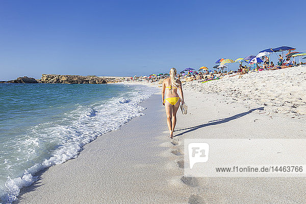 Junges Mädchen in einem gelben Badeanzug geht am Strand von Is Arutas  Cabras  Provinz Oristano  Sardinien  Italien  Mittelmeer