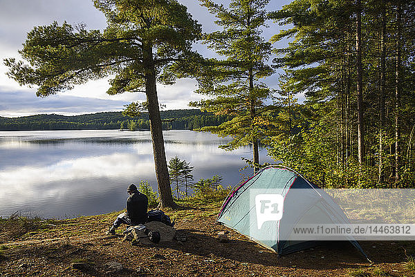 Hiker camping by Provoking Lake in Algonquin Provincial Park  Ontario  Canada  North America