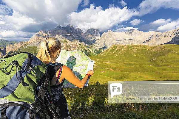 Wanderer beim Lesen der Karte mit der Marmolada im Hintergrund  San Nicolo Pass  Fassa Tal  Trentino  Dolomiten  Italien