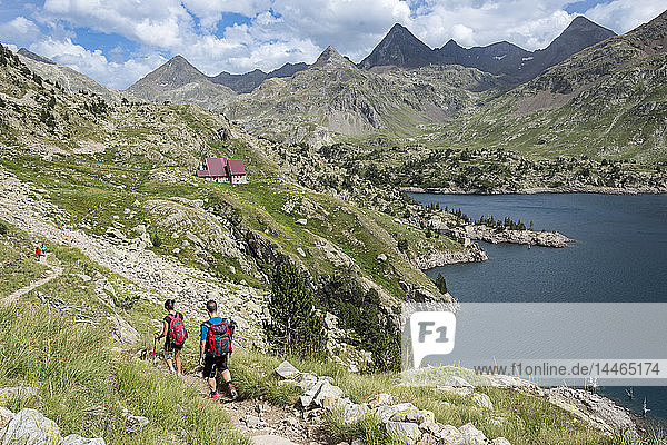 Hikers make their way along the the long distance footpath called the GR11 towards Refugio Respomuso in the Spanish Pyrenees  Huesca  Spain