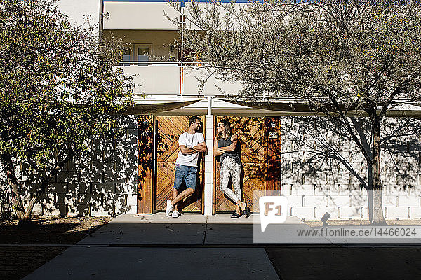 USA  California  Palm Springs  smiling couple standing at house entrance