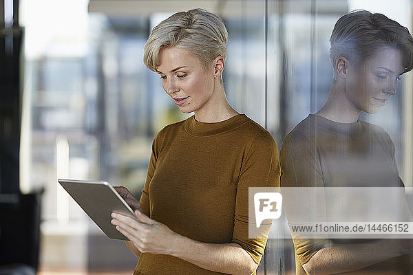 Geschäftsfrau mit Tablett am Fenster