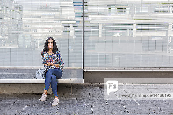 Porträt einer reifen Frau mit Smartphone im Freien