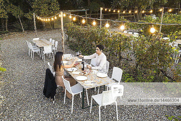 Italien  Toskana  Siena  junges Paar beim Abendessen in einem Weinberg