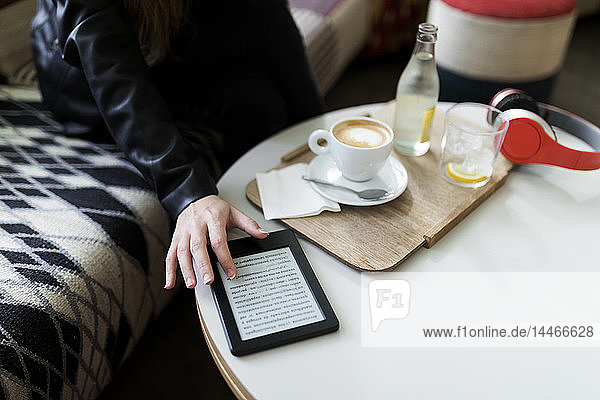 Nahaufnahme einer jungen Frau in einem Cafe mit einem E-Book