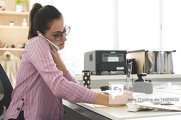 Designer im Büro arbeiten  Laptop benutzen  telefonieren
