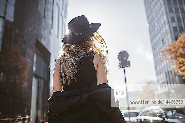 Rückenansicht einer Frau mit Hut in schwarz gekleidet