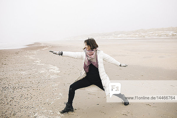 Frau macht Yoga-Übungen am Strand