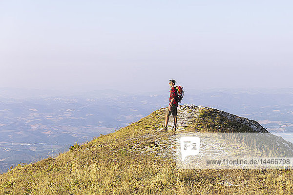 Italien  Monte Nerone  Wanderer auf dem Gipfel eines Berges mit Panoramablick