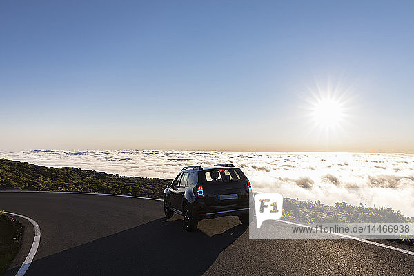 Reunion  Nationalpark Reunion  Auto auf der Straße zum Maido-Aussichtspunkt  Wolkenmeer und Sonnenlicht