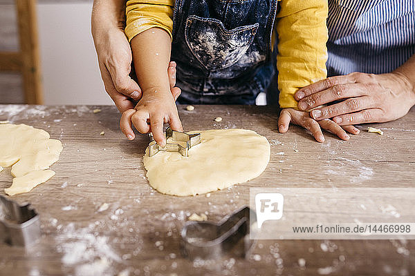 Mutter und Sohn schneiden gemeinsam Kekse aus  Teilansicht