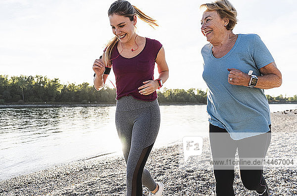 Enkelin und Großmutter amüsieren sich  joggen gemeinsam am Fluss