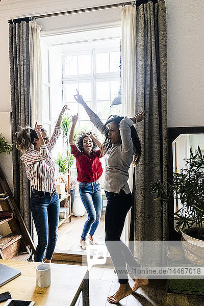 Drei Frauen zu Hause feiern und tanzen