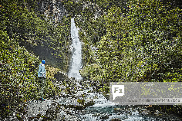 Chile  Nationalpark Laguna San Rafael  Frau bewundert den Wasserfall Las Cascadas