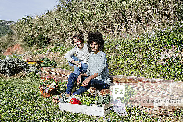 Couple sitting in their vegetable garden  having a picnic after harvesting