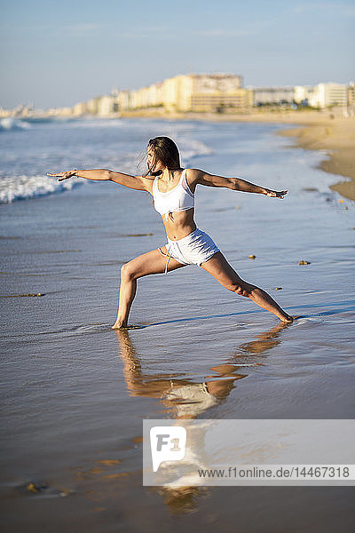 Sportliche Frau macht Yoga am Strand