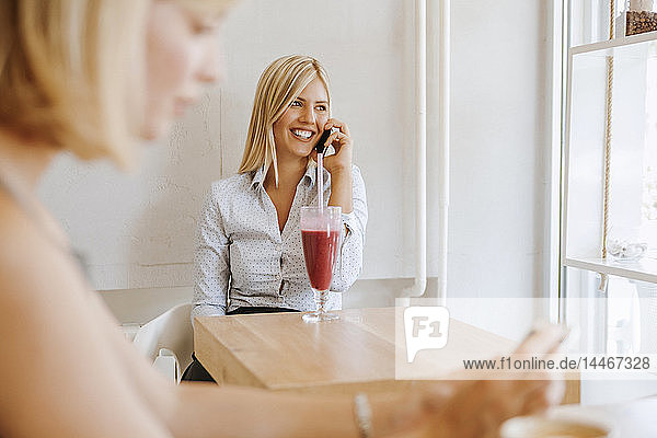 Junge Frauen am Handy in einem Cafe