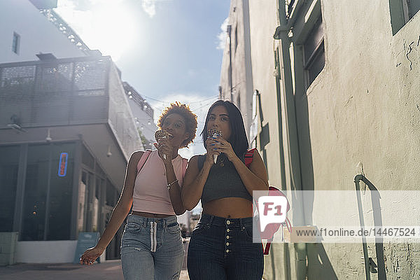 USA  Florida  Miami Beach  two female friends eating ice cream cones in the city