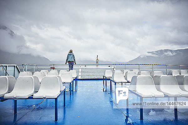 Chile  Hornopiren  Frau steht an der Reling einer Fähre und schaut auf den Fjord