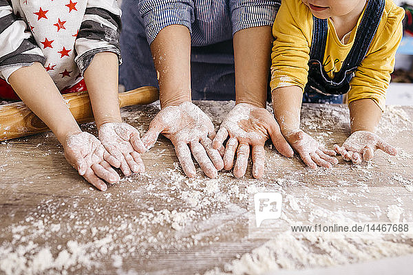 Mutter und Kinder mit Mehl an den Händen  Teilansicht