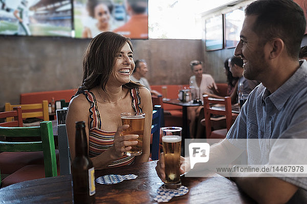 Happy couple drinking beer in a bar