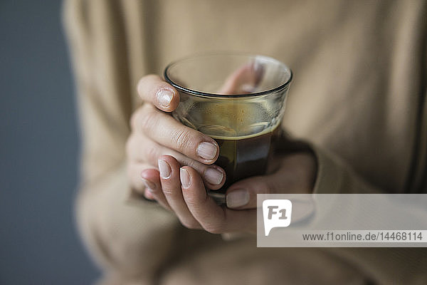 Frauenhände halten ein Glas Kaffee  Nahaufnahme