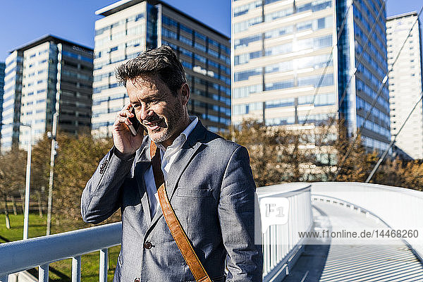 Businessman walking on a bridge  talking on the phone