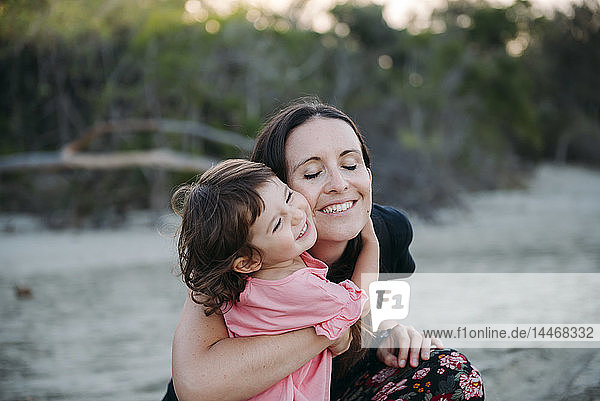 Australia  Queensland  Mackay  Cape Hillsborough National Park  happy mother hugging her daughter at the beach