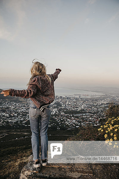 Südafrika  Kapstadt  Kloof Nek  glückliche Frau  die bei Sonnenuntergang die Aussicht genießt